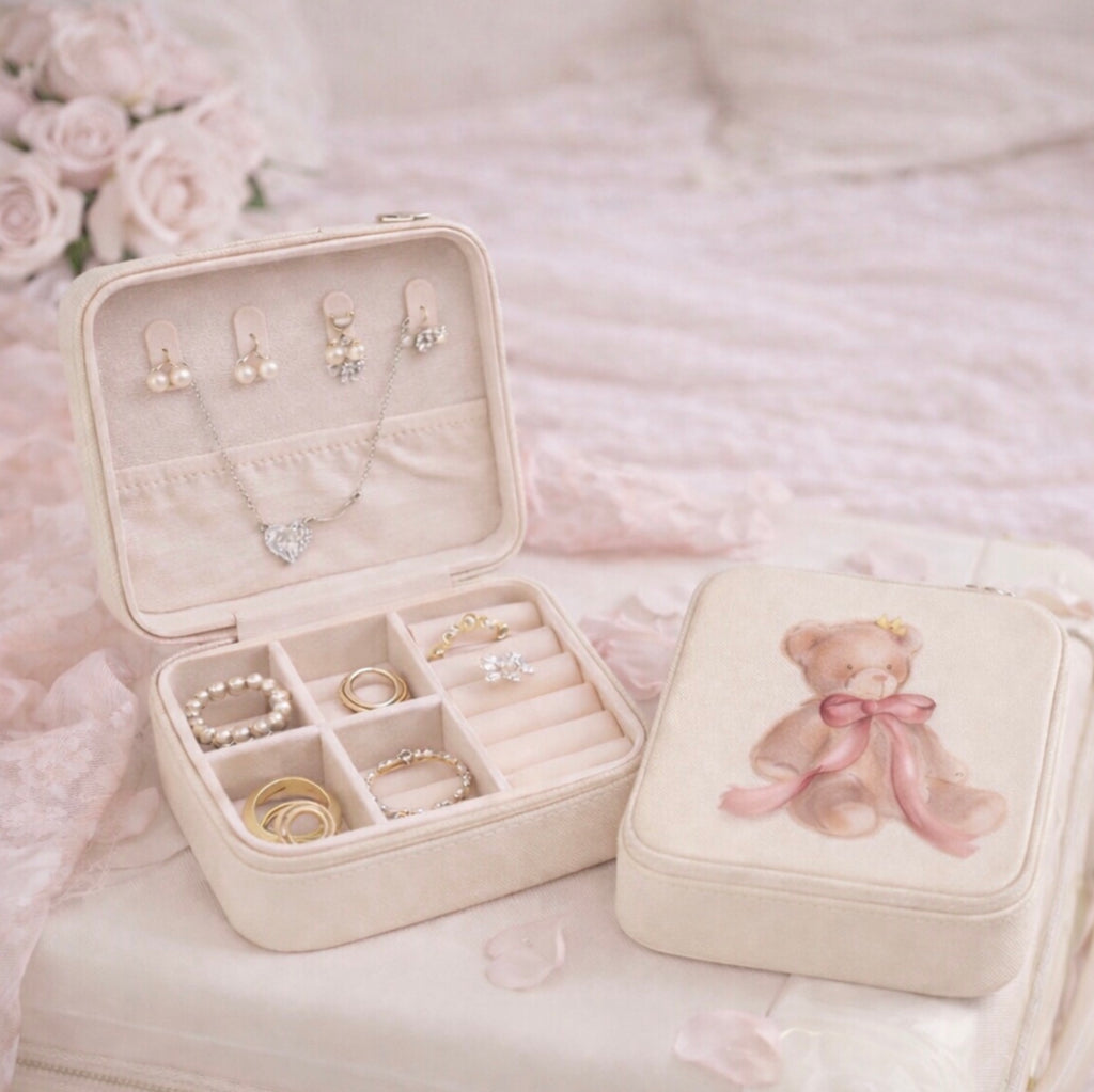 Jewelry box with jewelry and a teddy bear design on a soft pink background